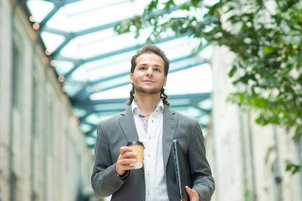 A young successful businessman is walking down the street. Man in a casual wear. Business, freelance and remote work. — Stock Photo, Image