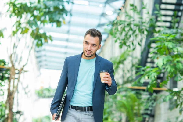 Um jovem empresário de sucesso está andando pela rua. Um homem de fato casual. Trabalho de negócios, freelance e remoto. — Fotografia de Stock