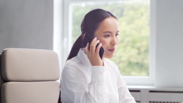 Asiatische Geschäftsfrau an ihrem Tisch in einem modernen Büro. Der Arbeitsplatz eines erfolgreichen Spezialisten. Geschäfts- und Finanzierungskonzept. — Stockvideo