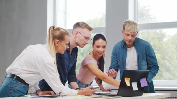 Het team van jonge startupers werkt aan de tafel in het kantoor en bespreekt de strategie en het ontwikkelingsplan van het bedrijf. Bedrijfs-, innovatie-, brainstorm- en teamwerkconcept. — Stockvideo