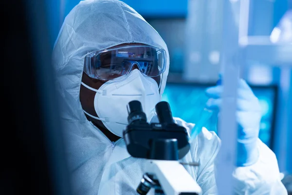 Cientista afro-americano trabalha em um laboratório científico usando equipamentos de laboratório, microscópio e tecnologia da computação. Invenção de novos medicamentos e vacinas. Conceito de Ciência e Saúde. — Fotografia de Stock