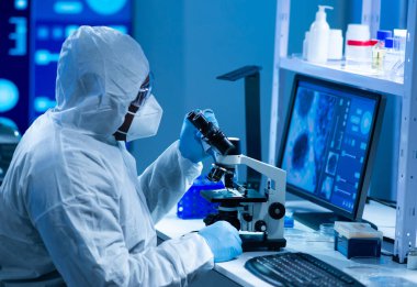 Afrikalı-Amerikalı bilim adamı laboratuvar ekipmanları, mikroskop ve bilgisayar teknolojisi kullanarak bir laboratuarda çalışıyor. Yeni ilaçların ve aşıların icadı. Bilim ve Sağlık kavramı.