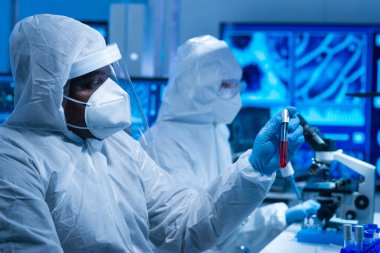 Afrikalı-Amerikalı bilim adamı laboratuvar ekipmanları, mikroskop ve bilgisayar teknolojisi kullanarak bir laboratuarda çalışıyor. Yeni ilaçların ve aşıların icadı. Bilim ve Sağlık kavramı.
