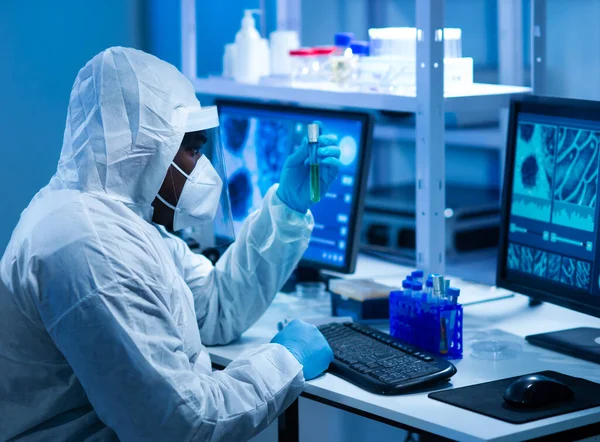Científico afroamericano trabaja en un laboratorio científico usando equipo de laboratorio, microscopio y tecnología informática. Invención de nuevos fármacos y vacunas. Concepto de Ciencia y Salud. — Foto de Stock