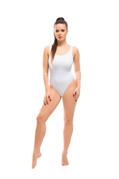 Mulher morena jovem, em forma e bonita em maiô branco isolado no fundo branco. Cuidados de saúde, dieta, esporte e fitness. — Fotografia de Stock