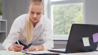 Serbest çalışan bir işçinin ya da öğrenci bir kızın çalıştığı yer. Genç kadın bilgisayar ve diğer cihazları kullanarak çalışıyor. Uzak görev konsepti.