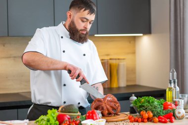 Genç aşçı modern bir mutfakta ahtapot kesiyor. Adam evde yemek hazırlıyor. Sağlıklı ve lezzetli yemekler pişirmek..