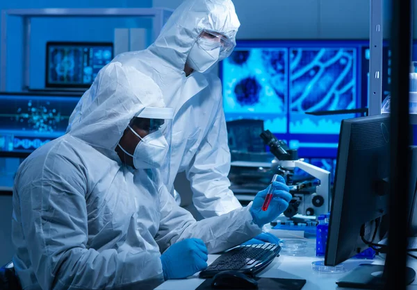 Afro-Amerikaanse dokter in beschermend pak doet een wetenschappelijk experiment en ontwikkelt een vaccin in een modern lab. Laboratoriumassistent op de werkplek. Het begrip wetenschap en geneeskunde. — Stockfoto