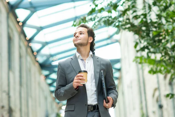 A young successful businessman is walking down the street. Man in a casual wear. Business, freelance and remote work. — Stock Photo, Image