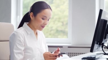 Modern bir ofiste masasında çalışan Asyalı bir iş kadını. Başarılı bir uzmanın işyeri. İş ve finans kavramı.