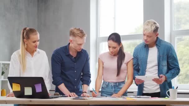 Zespół młodych startuperów pracuje przy stole w biurze, omawiając strategię i plan rozwoju firmy. Biznes, innowacje, burza mózgów i koncepcja pracy zespołowej. — Wideo stockowe