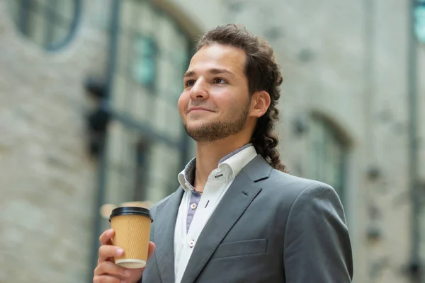 Un joven empresario exitoso está caminando por la calle. Un hombre con ropa casual. Negocios, freelance y trabajo remoto. — Foto de Stock