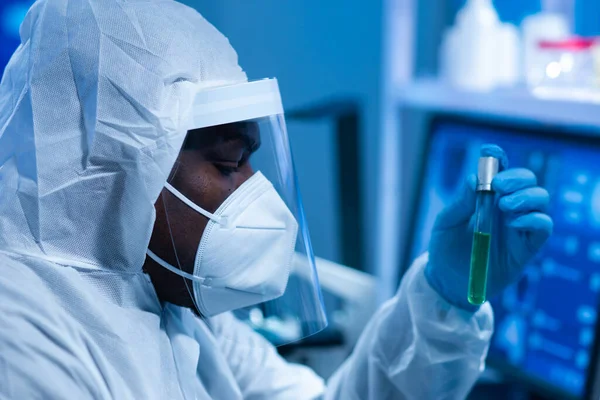 Il medico afro-americano in tuta protettiva sta facendo esperimenti scientifici e sviluppando vaccini in un laboratorio moderno. Assistente di laboratorio. Il concetto di scienza e medicina. — Foto Stock
