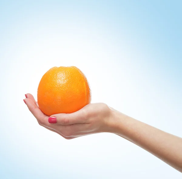 Hermosas manos femeninas con naranja —  Fotos de Stock