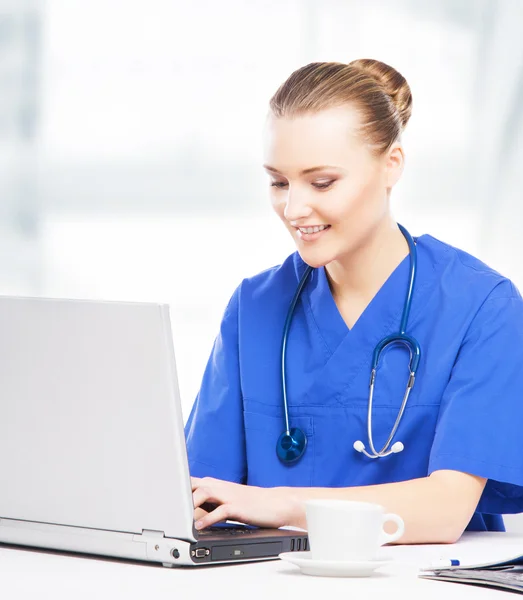 Jovem, profissional e alegre médico feminino trabalhando no escritório — Fotografia de Stock