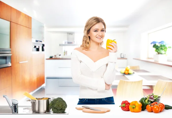 Jong en gelukkig vrouw koken in de keuken — Stockfoto