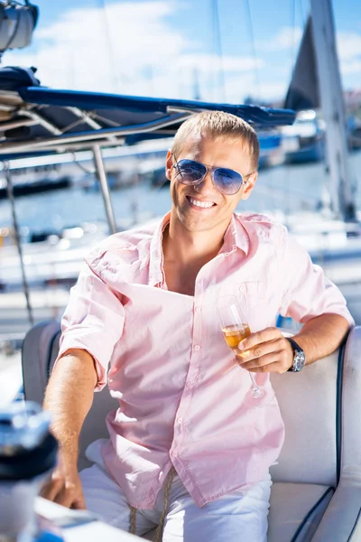 Young and handsome man in sunglasses on a boat — Stock Photo, Image