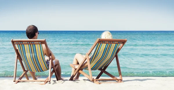 Paar sitzt in Strandkörben — Stockfoto