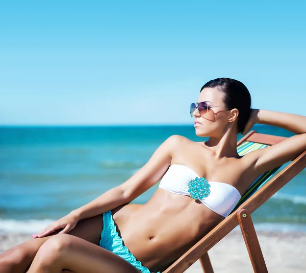 Mulher relaxante na cadeira de praia — Fotografia de Stock