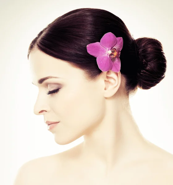 Donna con fiore di orchidea tra i capelli — Foto Stock