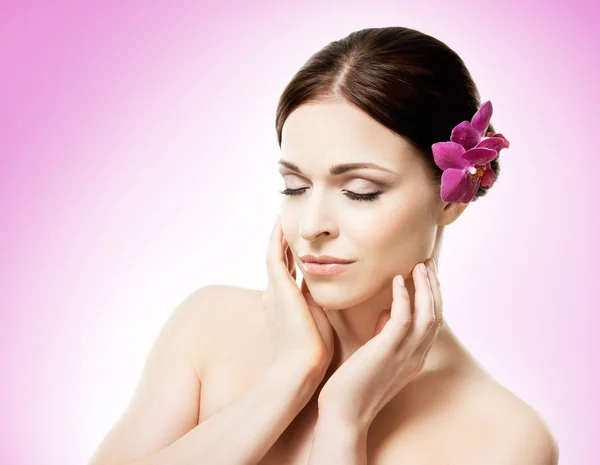 Mulher com flor de orquídea em seu cabelo — Fotografia de Stock