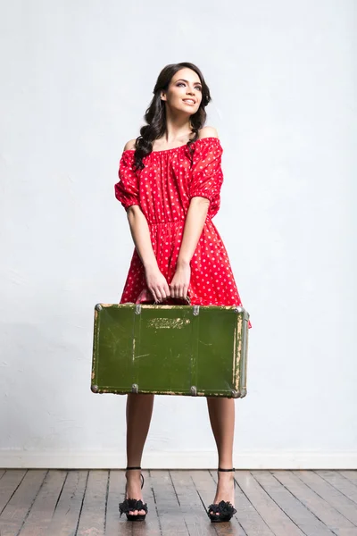 Woman with travel suitcase in red dress — Stock Photo, Image