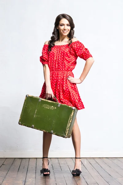 Γυναίκα με ταξίδια βαλίτσα με κόκκινο φόρεμα — Φωτογραφία Αρχείου
