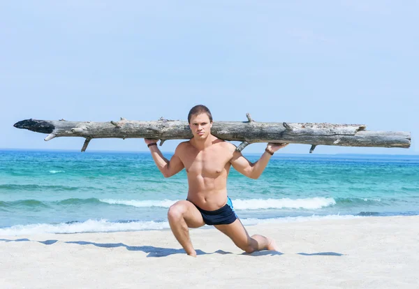 Homem musculado treinando na praia — Fotografia de Stock