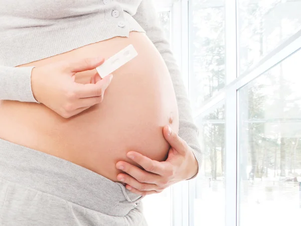 Teste de gravidez realizada e barriga grávida Imagens Royalty-Free