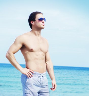 kaslı ve yakışıklı bir adam sahilde