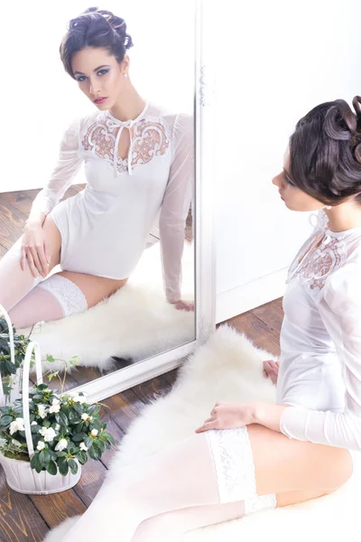 Женщина в свадебном белье, смотрящая в зеркало — стоковое фото