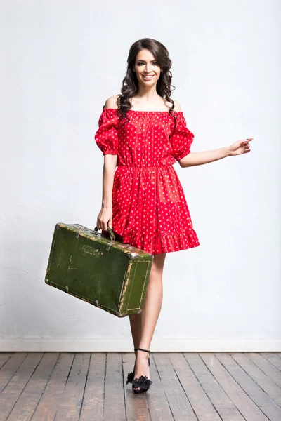 Woman in red dress with suitcase — Stock Photo, Image