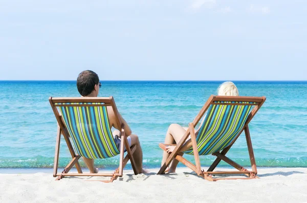 Mann und Frau chillen in Liegestühlen — Stockfoto