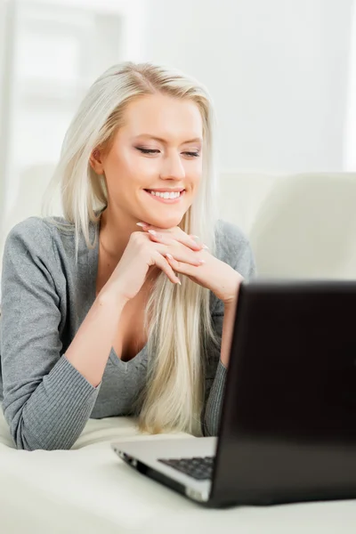 Kvinnan vila på soffan med laptop — Stockfoto