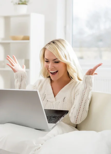 Mujer sentada en un sofá usando laptop —  Fotos de Stock