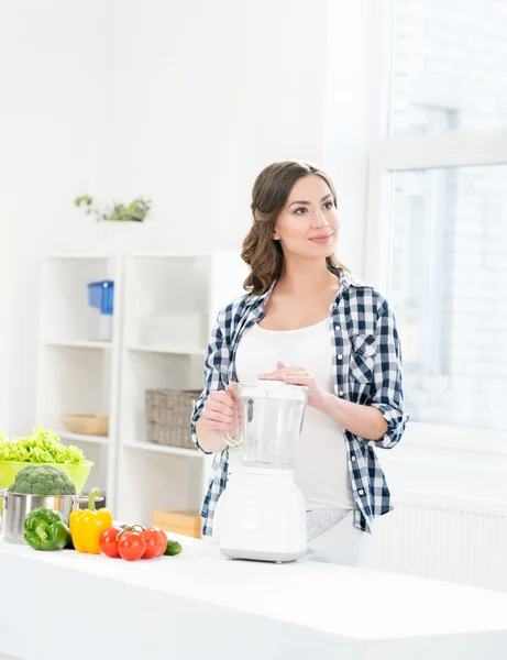 Těhotná žena, vaření s mixérem. — Stock fotografie