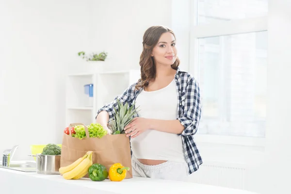 Zwangere vrouw met groenten en fruit — Stockfoto
