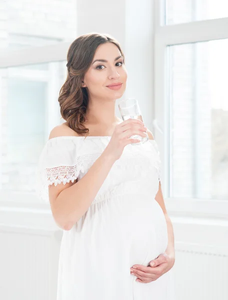 Donna incinta con bicchiere d'acqua — Foto Stock