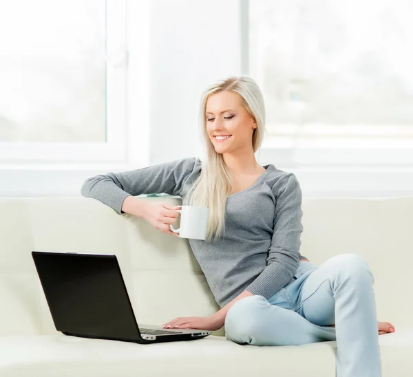 Frau benutzt Laptop und trinkt Kaffee — Stockfoto