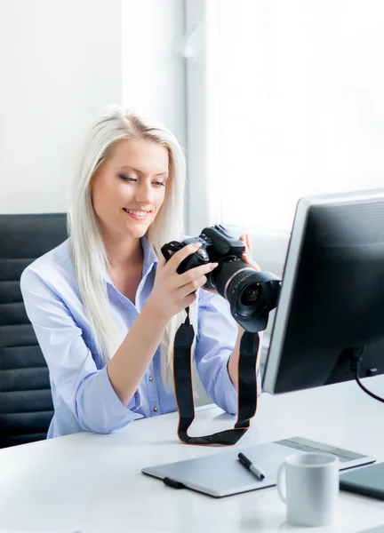 Mulher segurando câmera no escritório — Fotografia de Stock