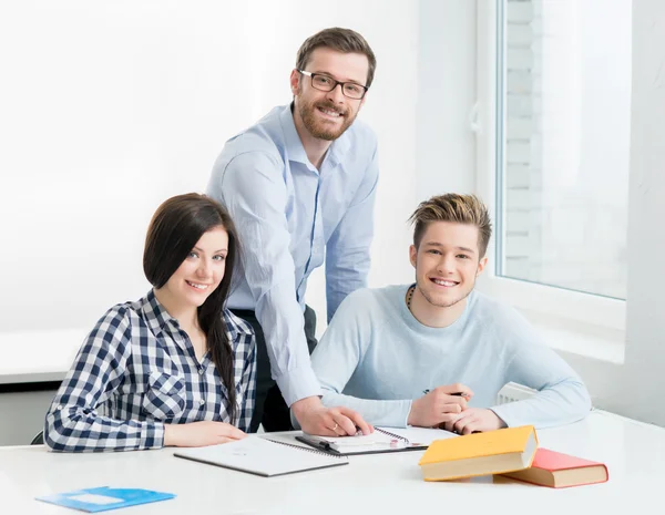 Teenage students with teacher in classroom — Stock Photo, Image