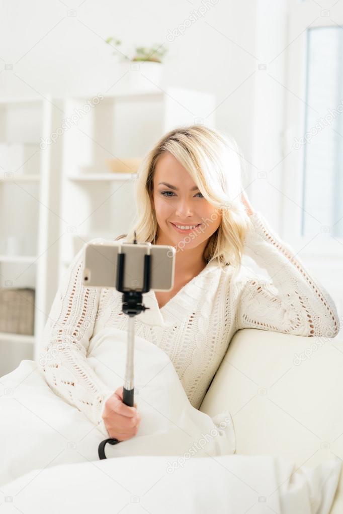 woman taking selfie with stick.