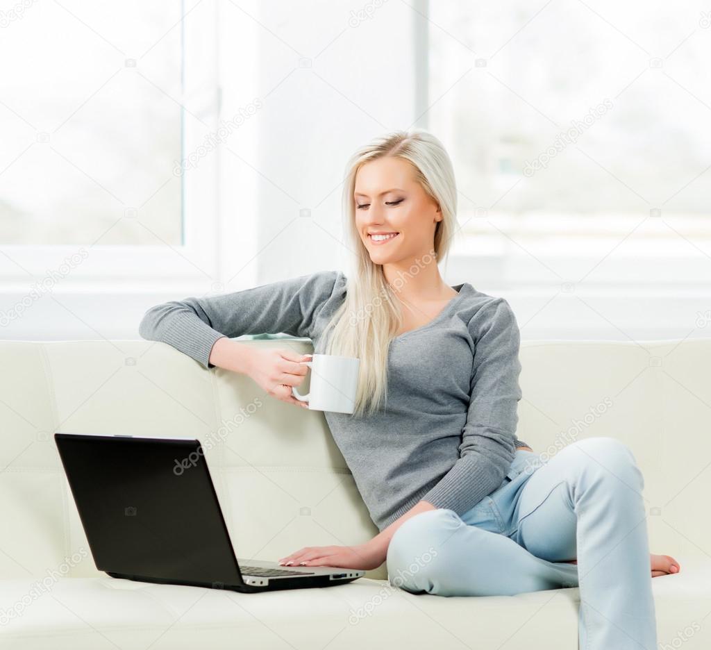 woman using laptop and drinking coffee
