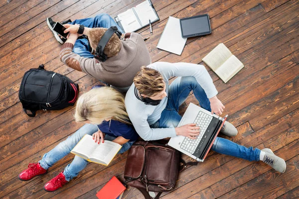 Schüler nutzen Smartphone, Laptop und Lesebuch — Stockfoto