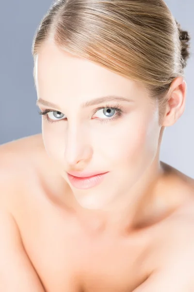 Krásná mladá žena s modrýma očima na šedém pozadí — Stock fotografie