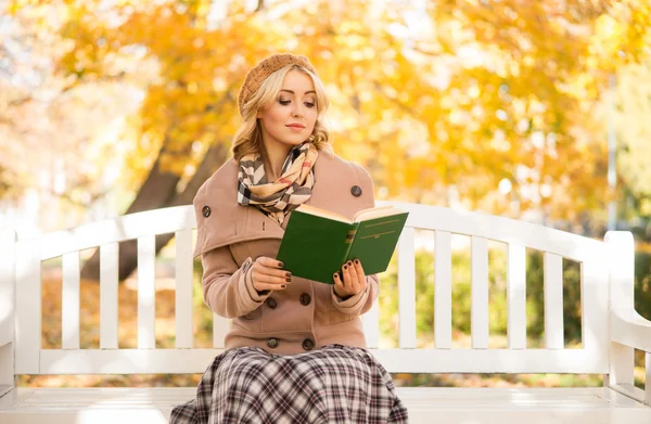 Sinnliches Mädchen liest auf der Bank sitzend im Park ein Gedichtbuch — Stockfoto