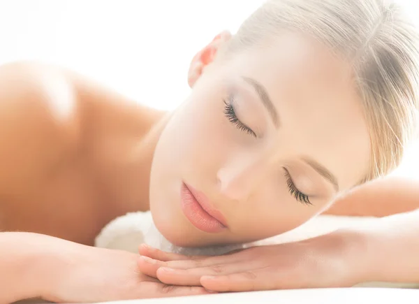 Beautiful young woman having leisure lying in a mat in spa