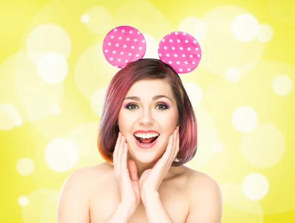 Krásná mladá usměvavá žena v Mickey mouse uši na bubliny pozadí — Stock fotografie