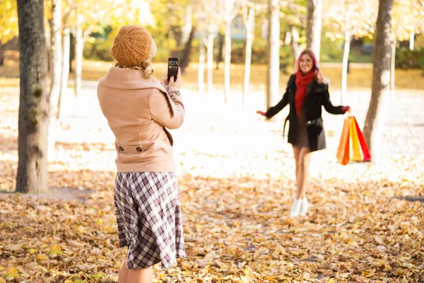 Två kvinnor som tar bilder på hösten efter shopping — Stockfoto