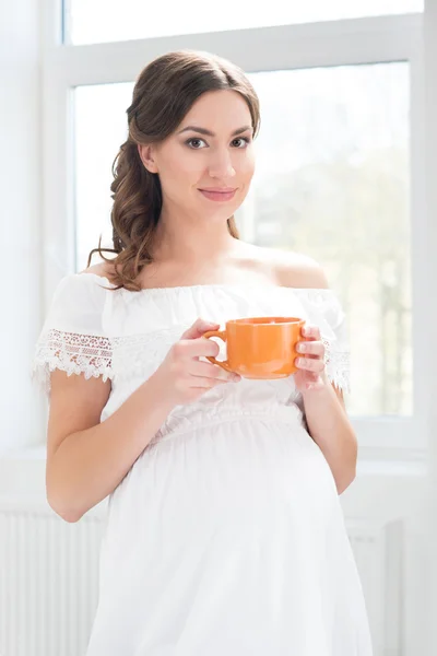 Belle femme enceinte prenant une tasse de café — Photo